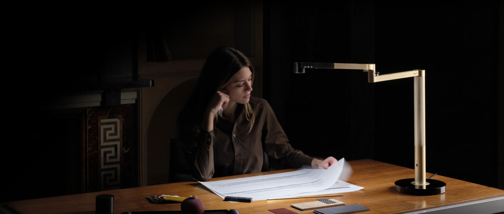 Propietaria trabajando en su escritorio con la lámpara de escritorio Dyson Solarcycle Morph.