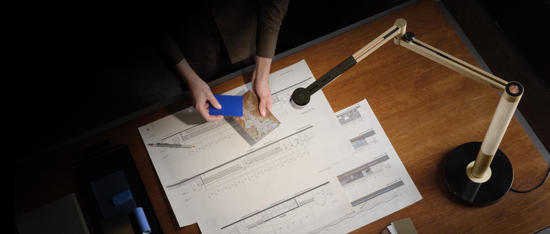Inżynier pracujący w świetle lampy biurkowej Dyson Solarcycle Morph.