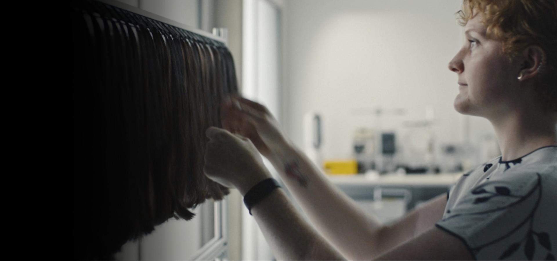 Ilmuwan rambut meneliti rambut di laboratorium