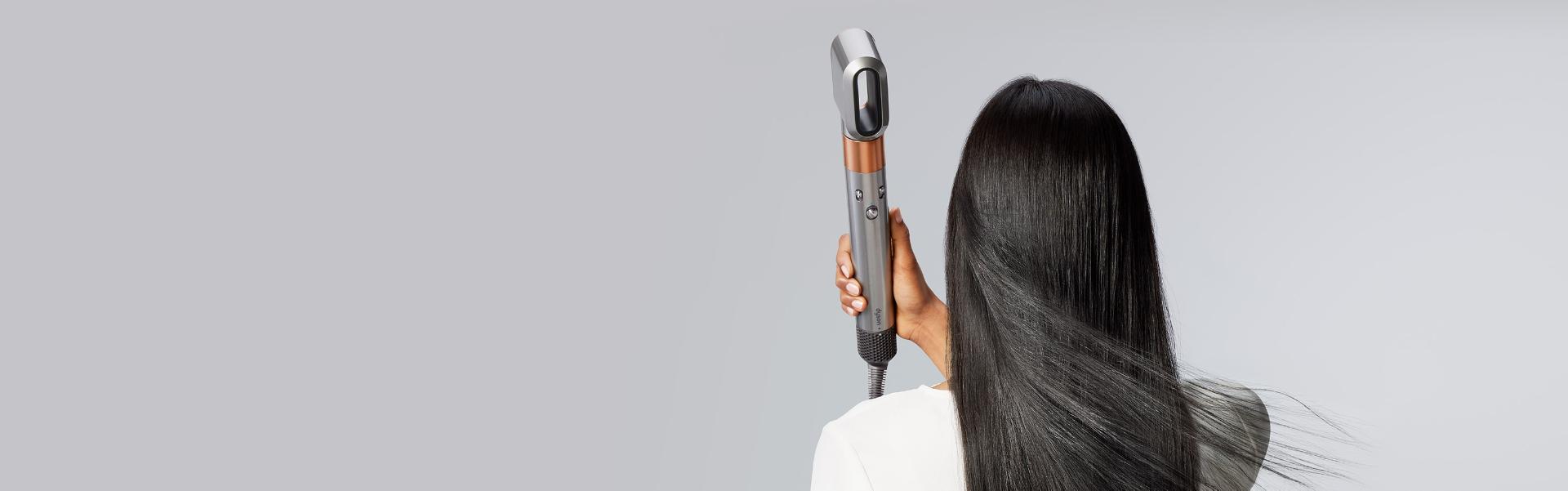Model using the fast dryer to dry hair
