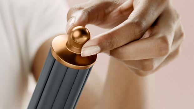 عارِضة تُمسك بملحق وحدة Airwrap الأسطوانية