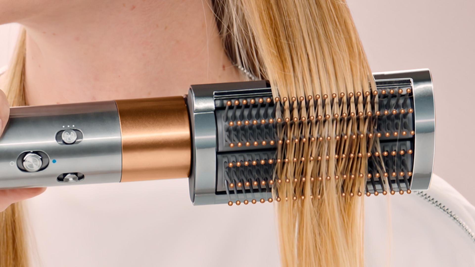 Model styling hair with The Dyson Airwrap multi-styler.