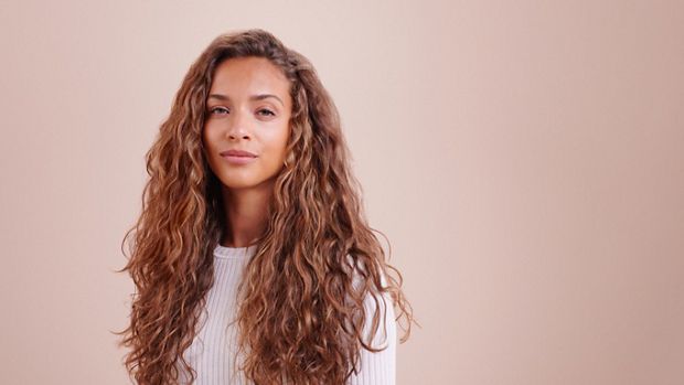 A model with styled wavy/curly hair