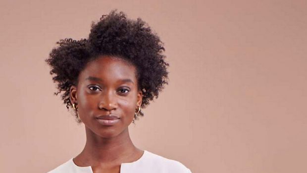 A model with styled coily hair.