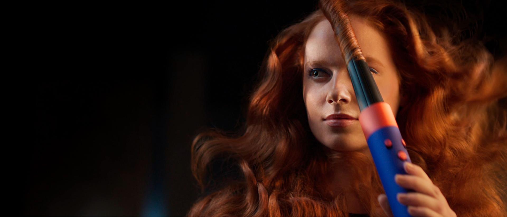 A redhead model sets her curl with a Cold shot from the Dyson Airwrap i.d. multi-styler and dryer.