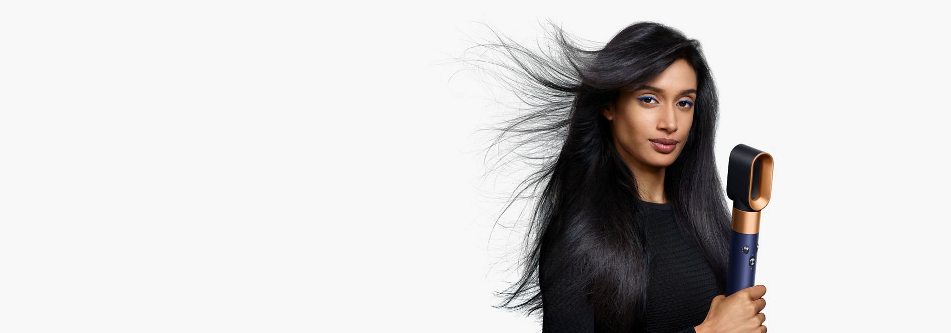 A model with long, dark hair uses the Fast dryer attachment to rough dry her hair.