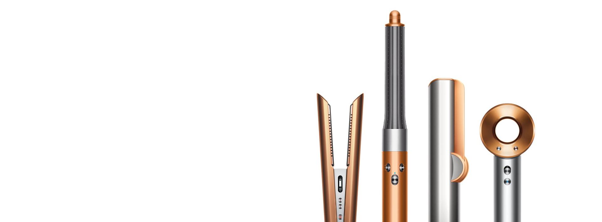 A line-up of Dyson hair care machines, in copper and nickel.