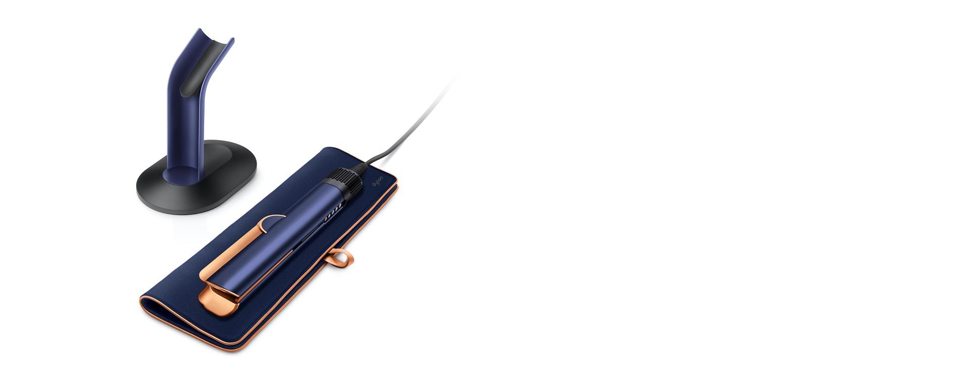 A Dyson Airstrait straightener resting on a travel pouch.