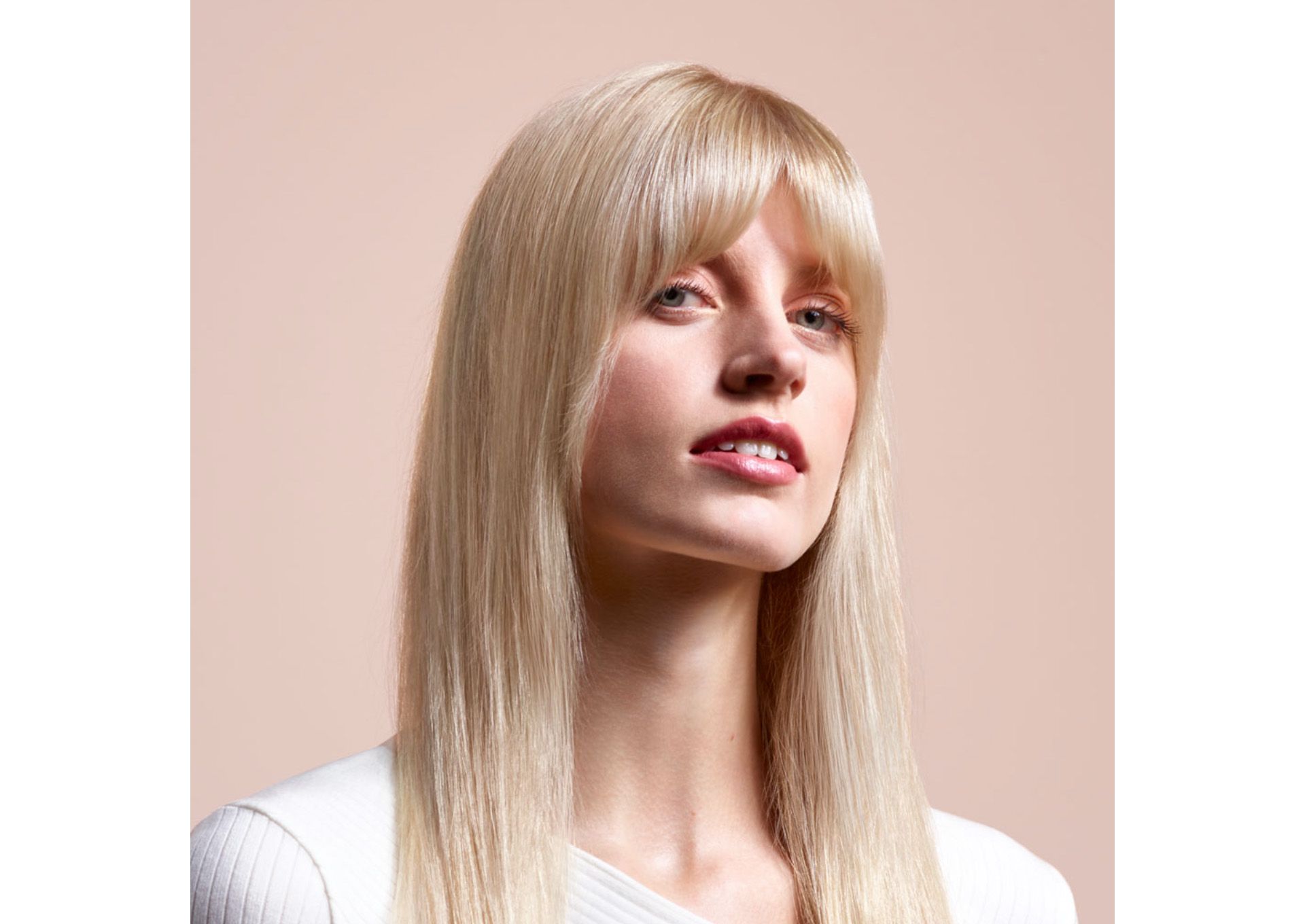 A model with long, blonde hair wearing a straight style.