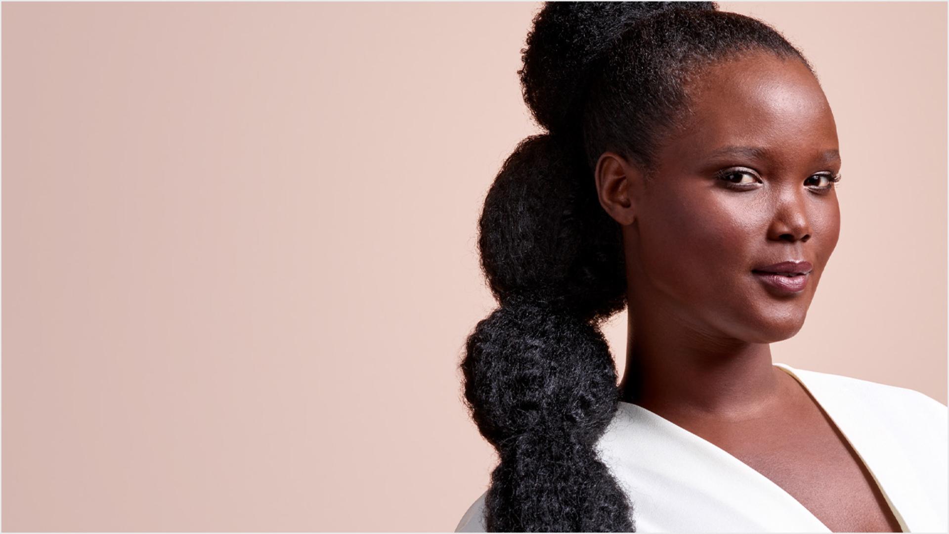 A model with long, black hair, worn in a stretched bubble puff ponytail.