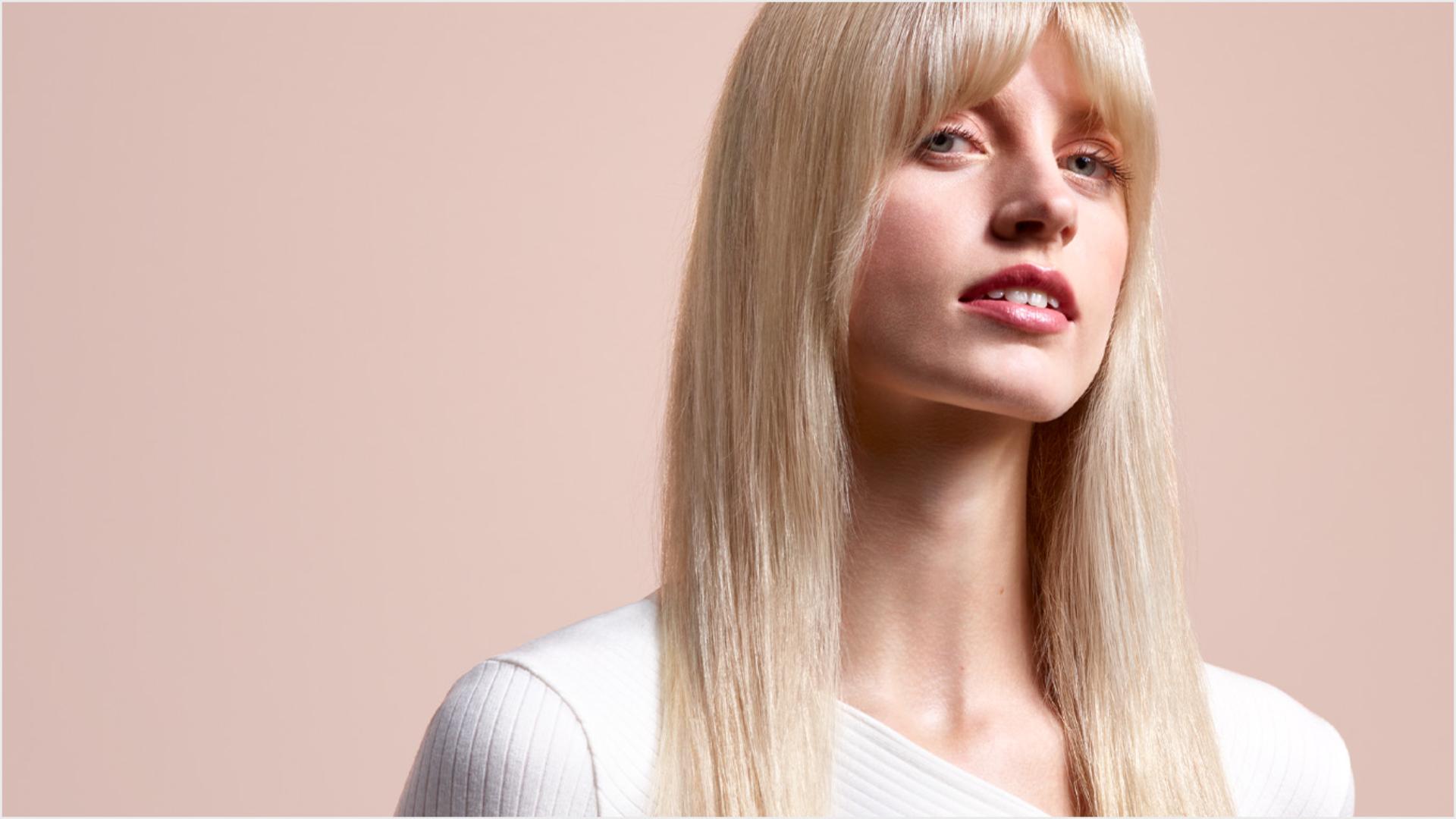 Modelka z długimi blond włosami z prostą, naturalną fryzurą.
