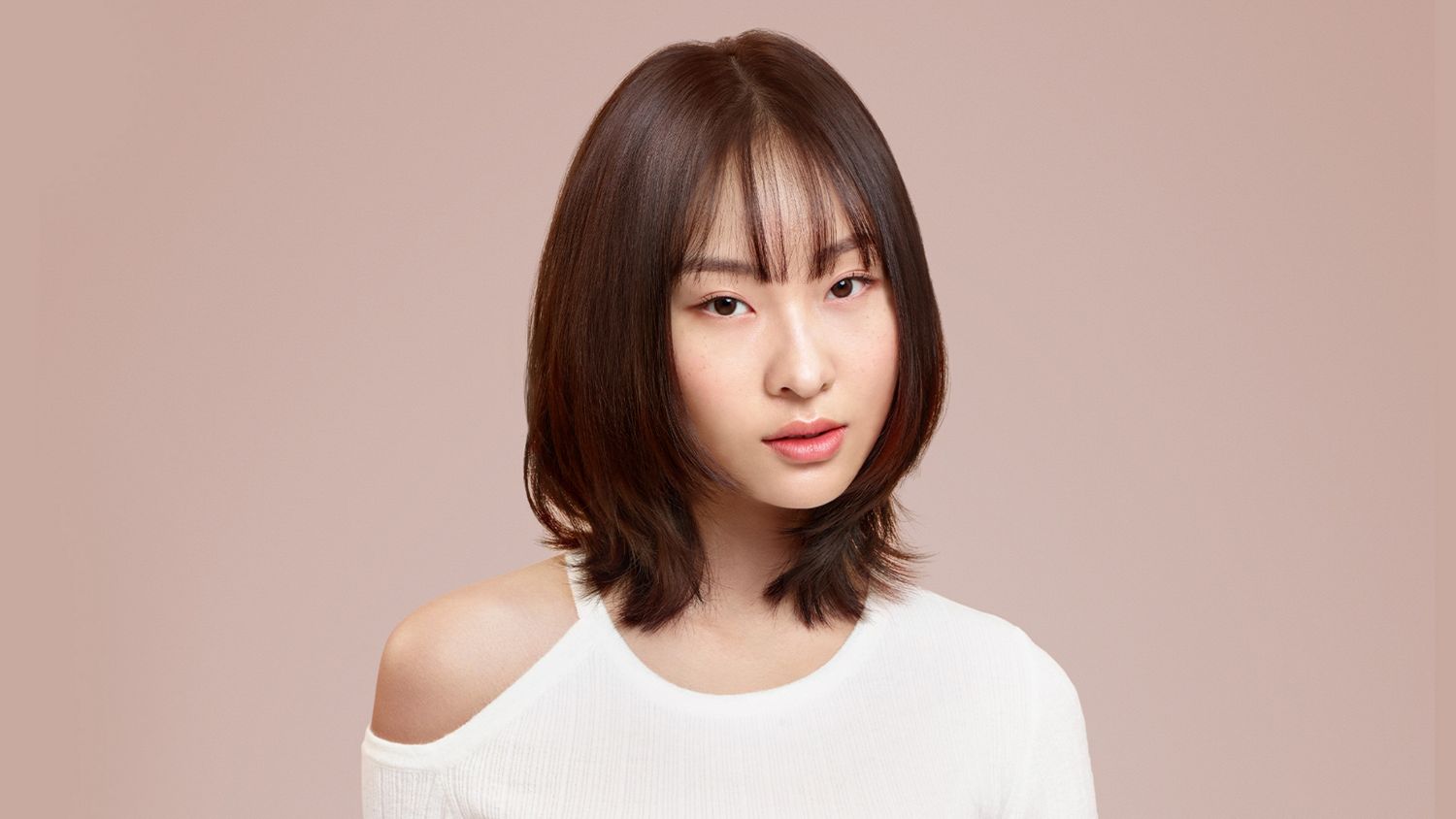 Femme avec des cheveux courts sur un fond rose