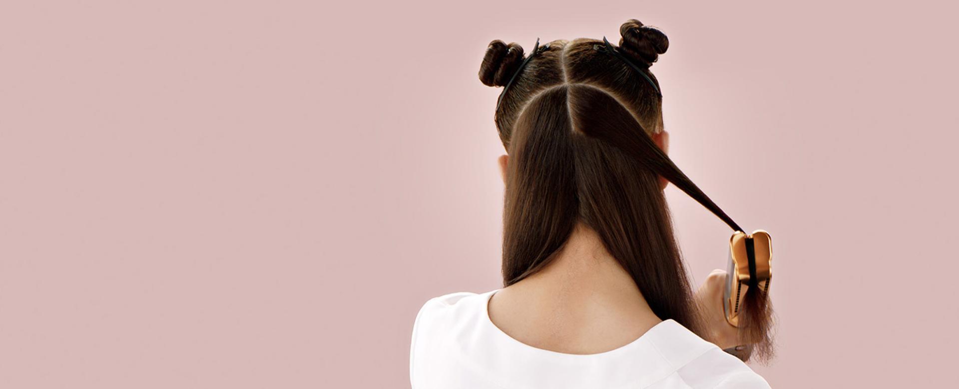 Tagantvaates modell kasutab Dyson Airstraiti juuste sirgendamiseks.