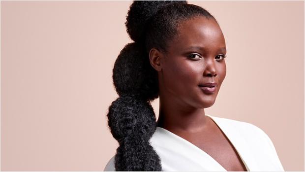 Modelka z długimi, czarnymi włosami spiętymi w kucyk w stylu