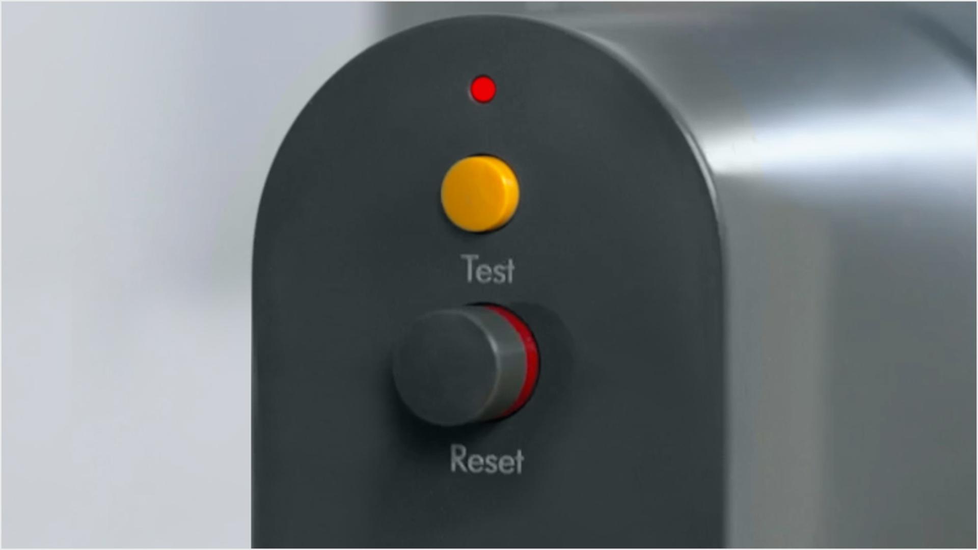 A close-up of both the test button and reset button on the PRCD plug, with the LED light lit above