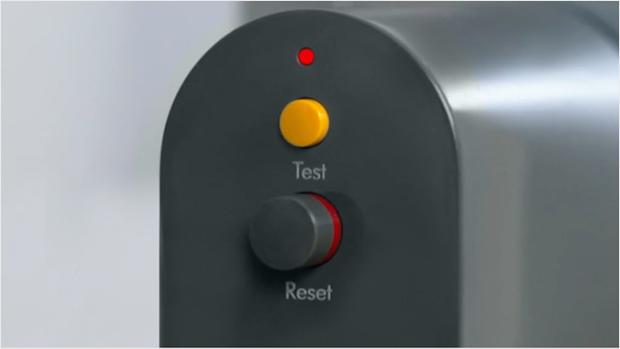A close-up of both the test button and reset button on the PRCD plug, with the LED light lit above