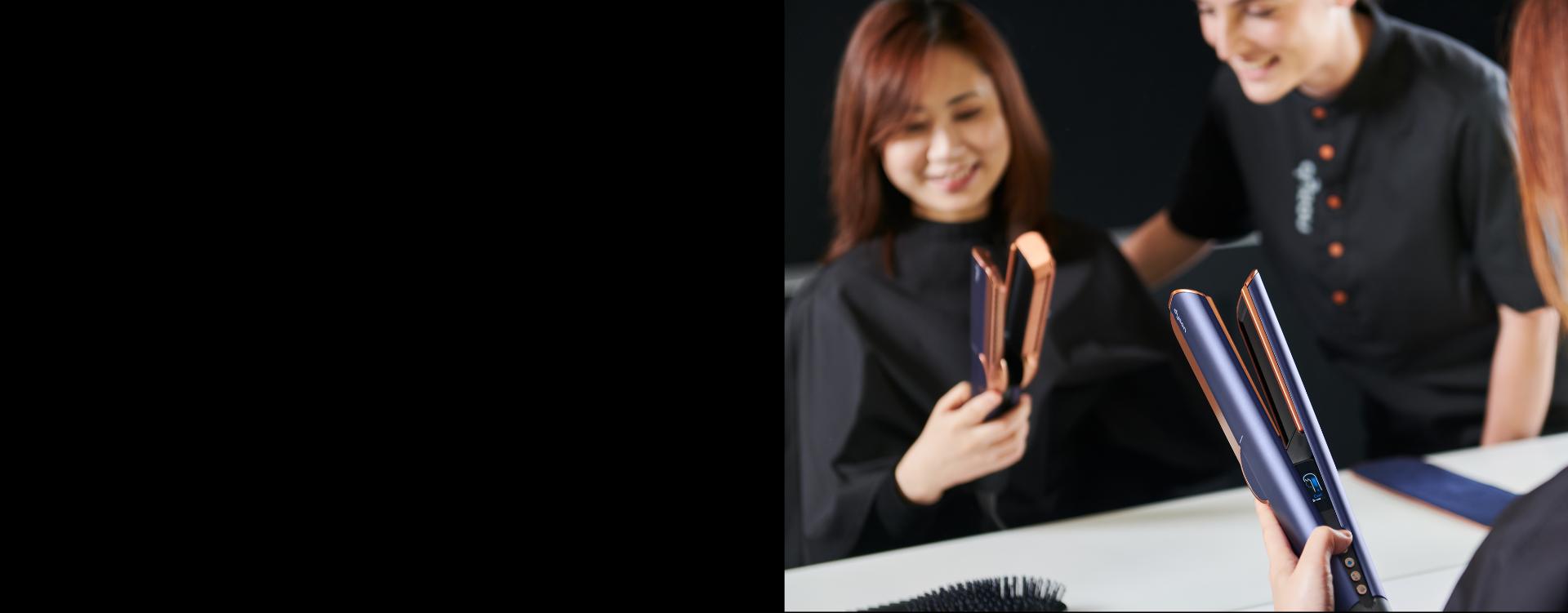 A customer tries the Dyson Airstrait straightener, guided by a Dyson Expert in store.