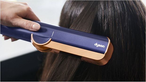 Close-up of model using the Dyson Airstrait on a tress of hair.