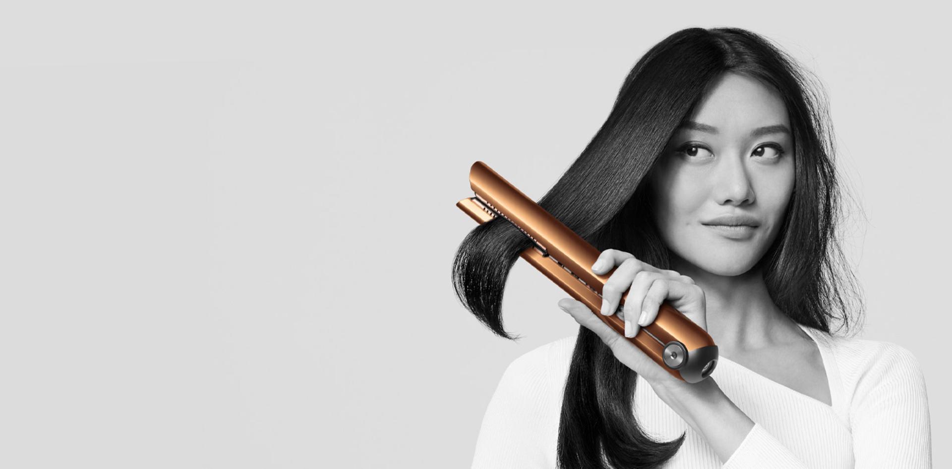 Model uses the Dyson Corrale straightener to style her hair
