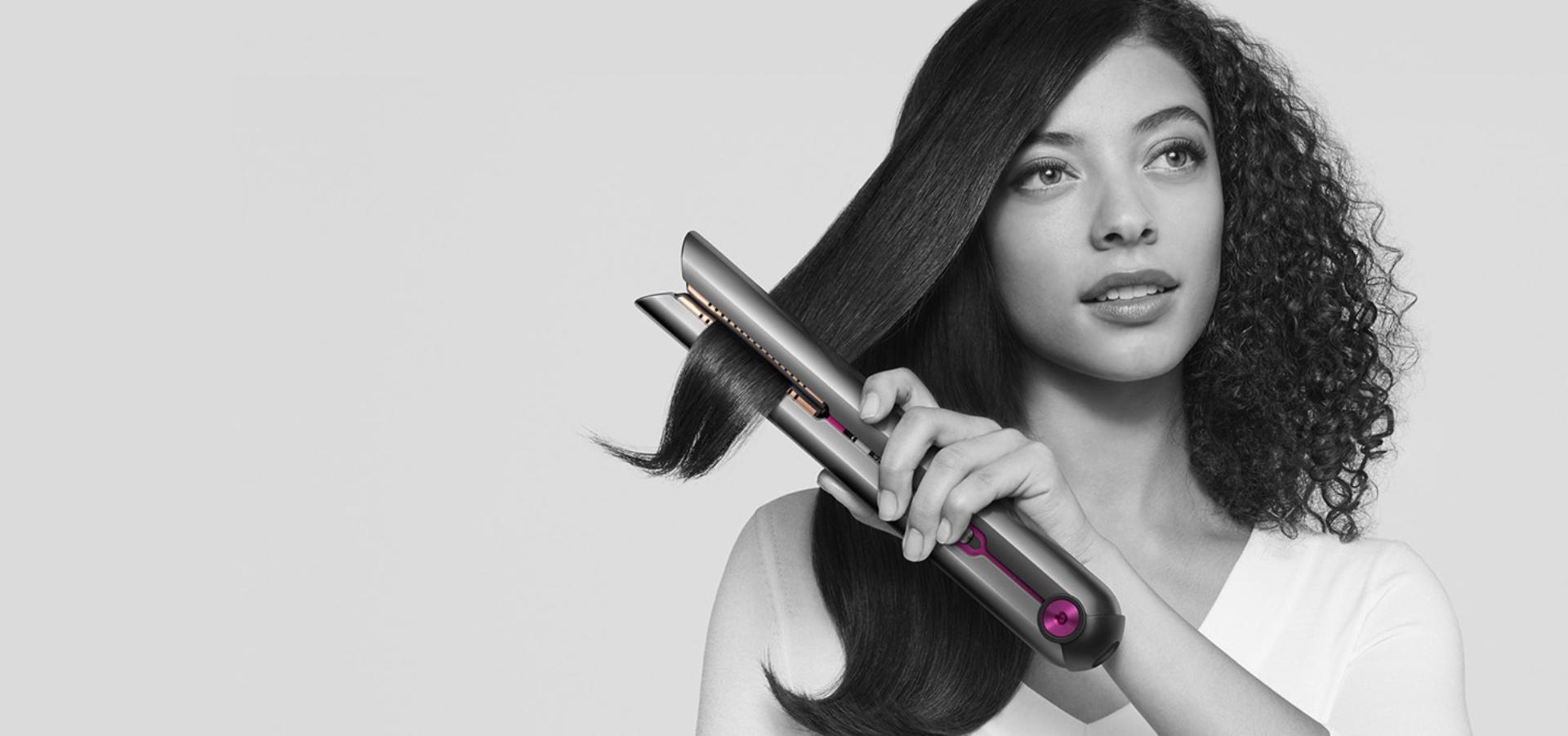 Woman achieving beautifully straight hair with the Dyson Corrale™ straightener