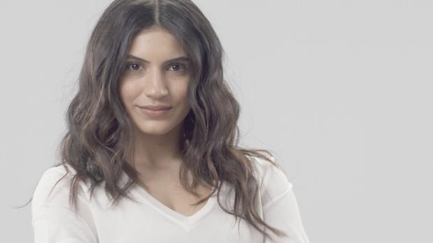 Moteris su tamsiomis, netaisyklingomis bangomis.