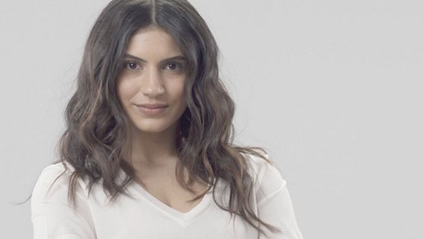 Moteris su tamsiomis, netaisyklingomis bangomis.