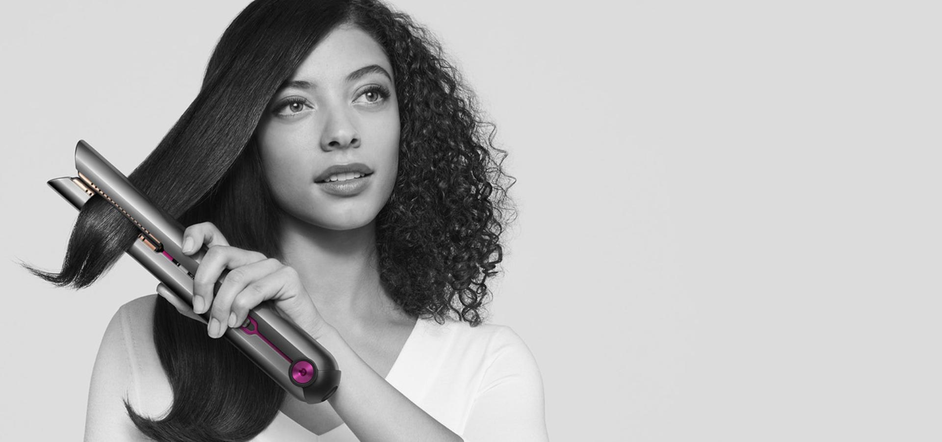 Woman straightening her hair with the Dyson Corrale™ straightener