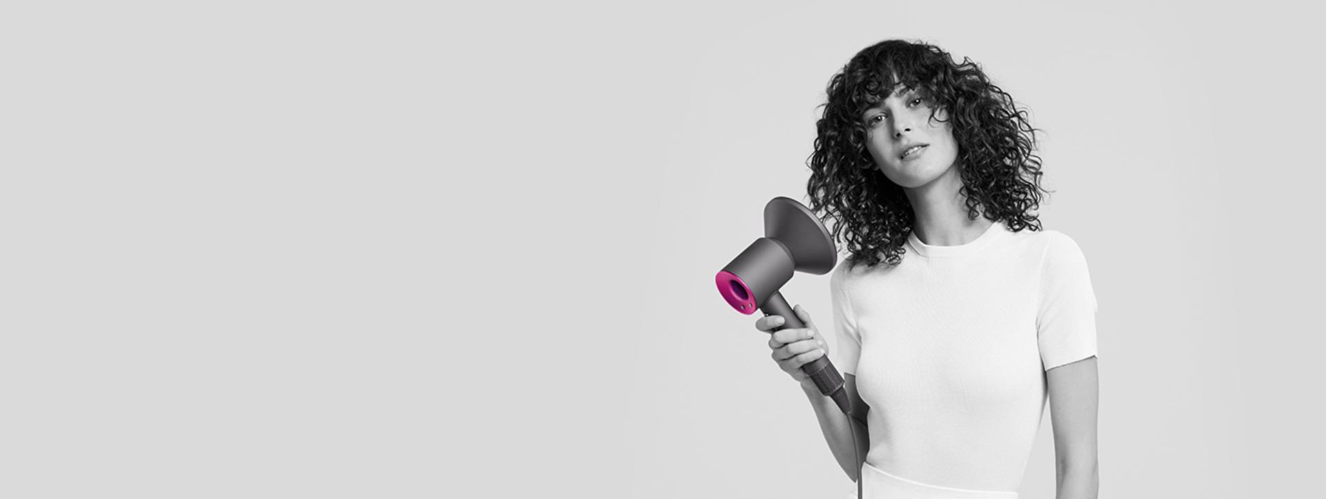 Woman using Dyson Supersonic with Diffuser attachment