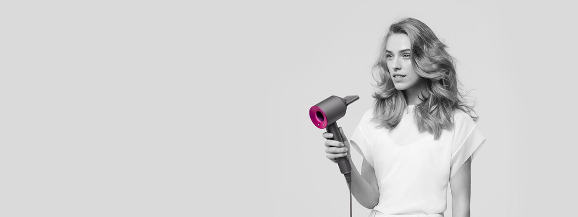 Woman using Dyson Supersonic with Styling concentrator attachment