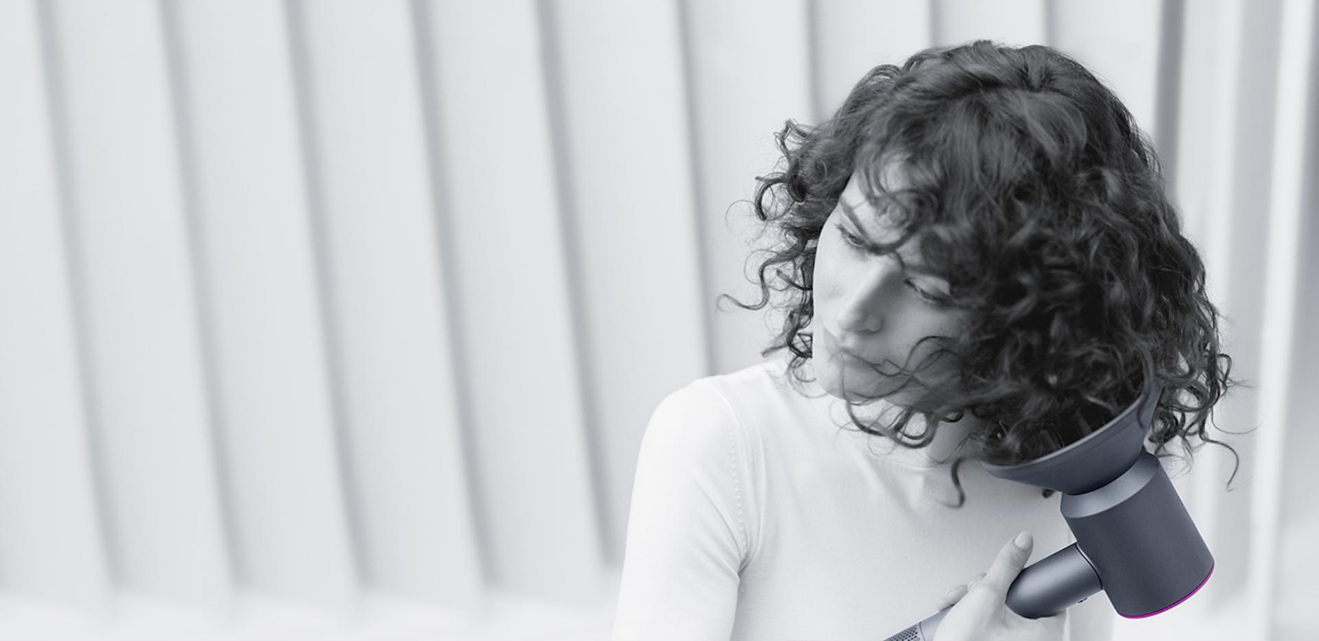 Woman drying her hair with Dyson supersonic