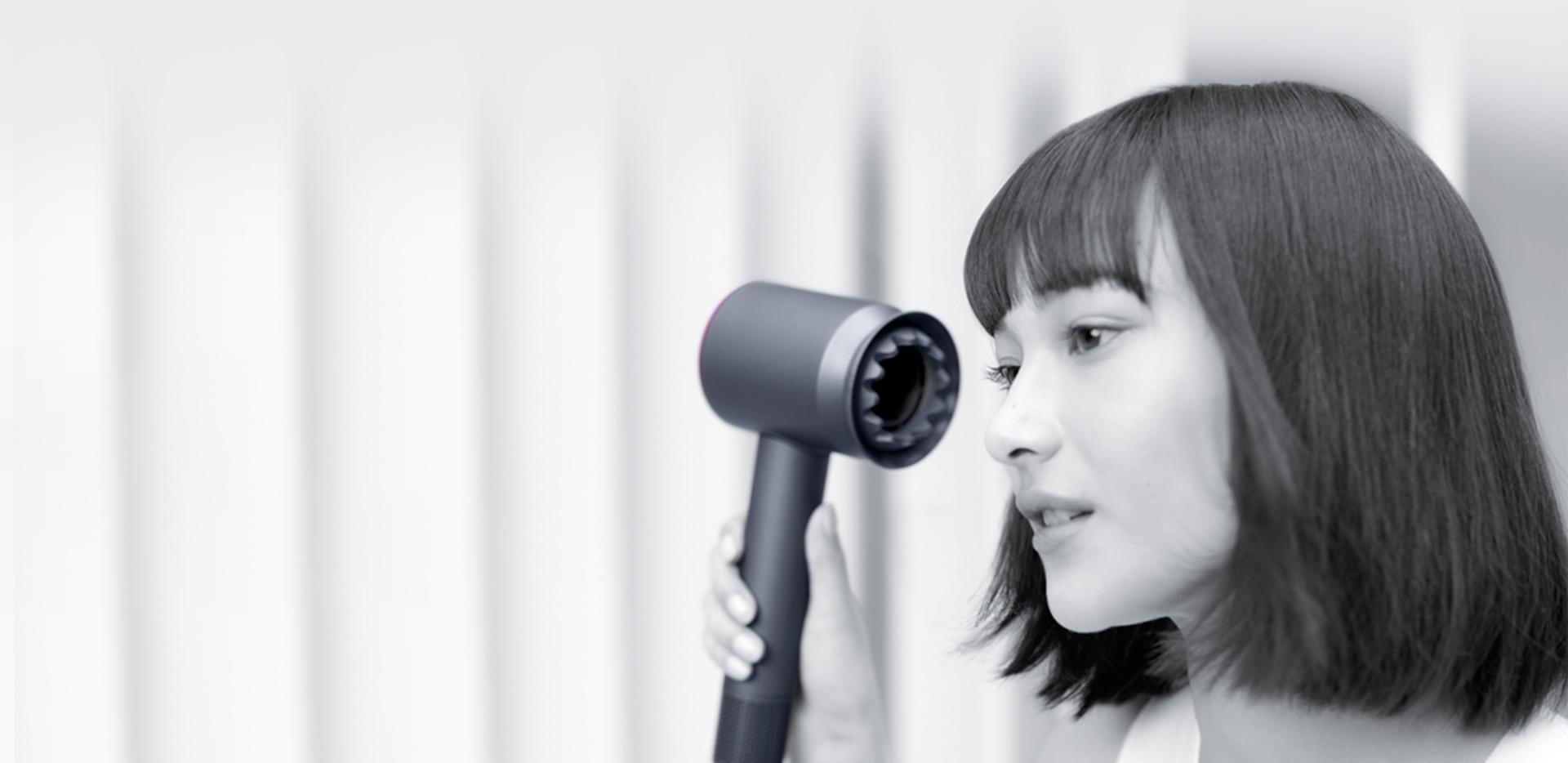 Người phụ nữ đang sấy tóc bằng máy sấy tóc Dyson Supersonic