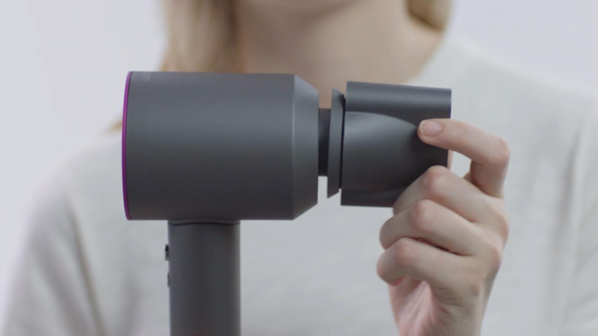 Woman clipping an attachment to her Dyson Supersonic™ hair dryer