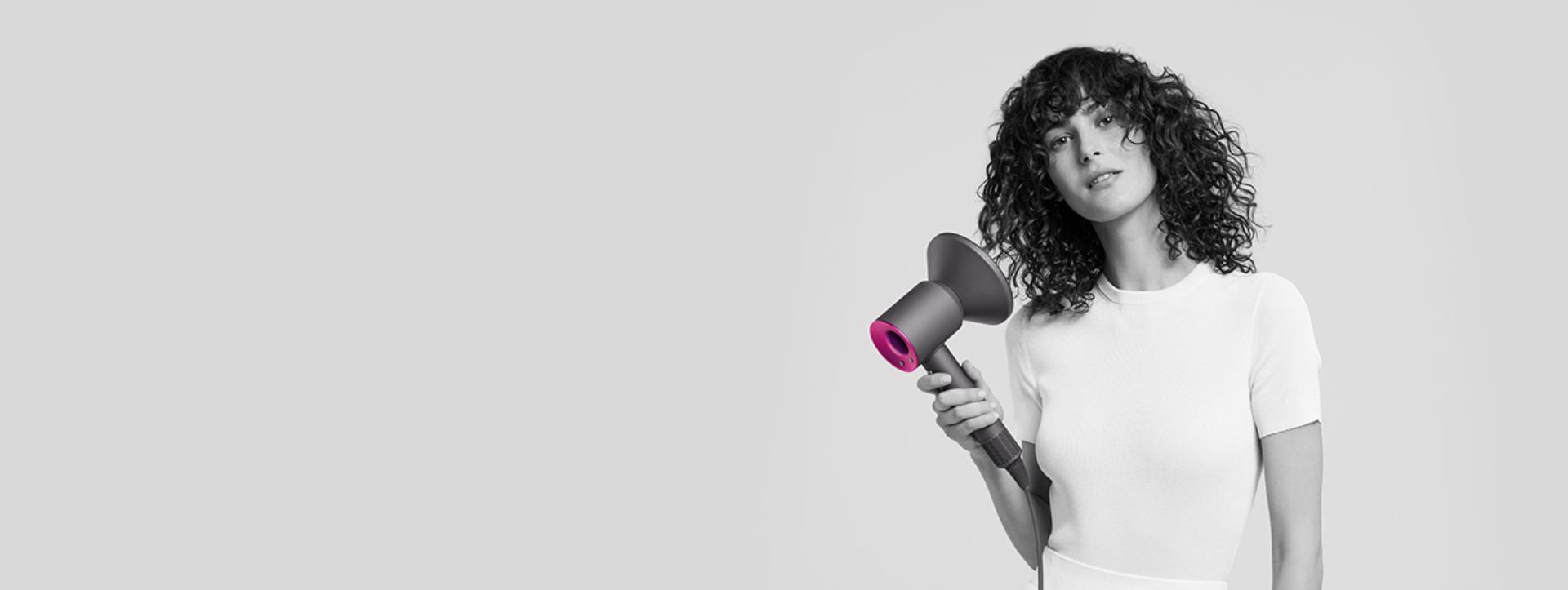 Woman using Dyson Supersonic with Diffuser attachment