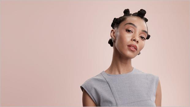 عارِضة شعرها مُصفَّف بتسريحة عُقد البانتو.