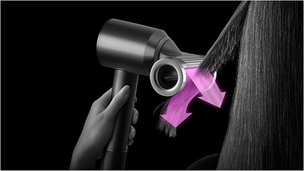 A tress of hair is styled using the Dyson Supersonic with Flyaway smoother attachment in Flyaway mode.