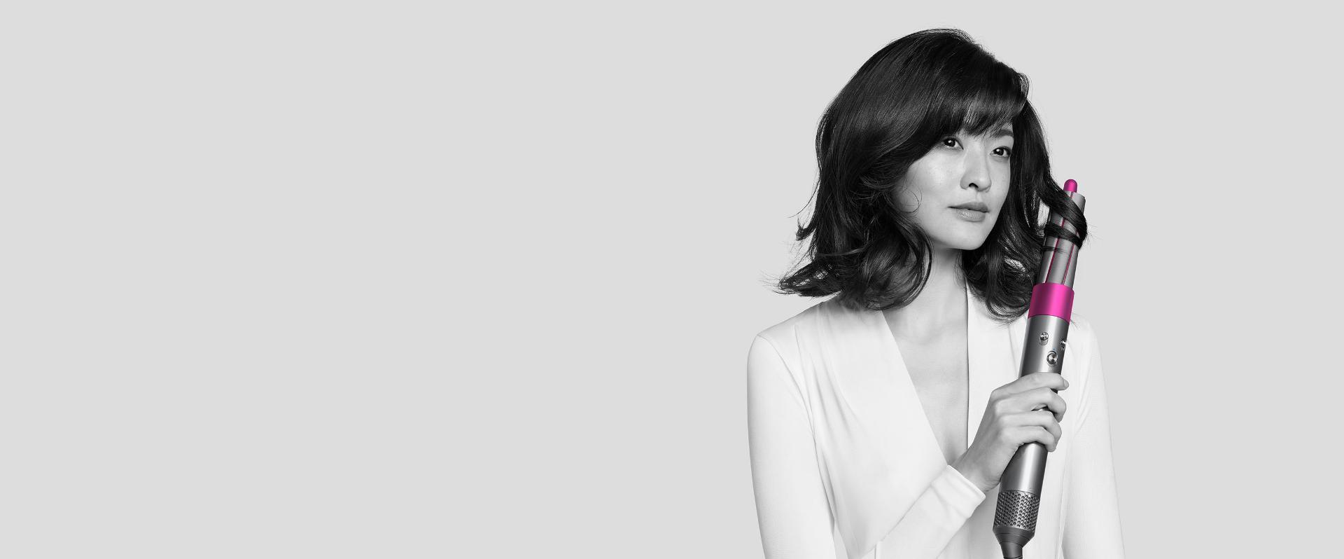Woman curls her hair with Dyson Airwrap styler.