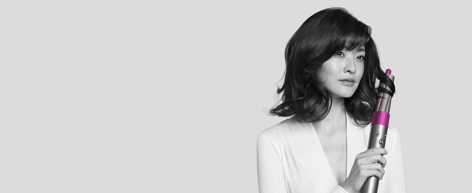 使用Dyson Airwrap™造型器捲髮的女士。