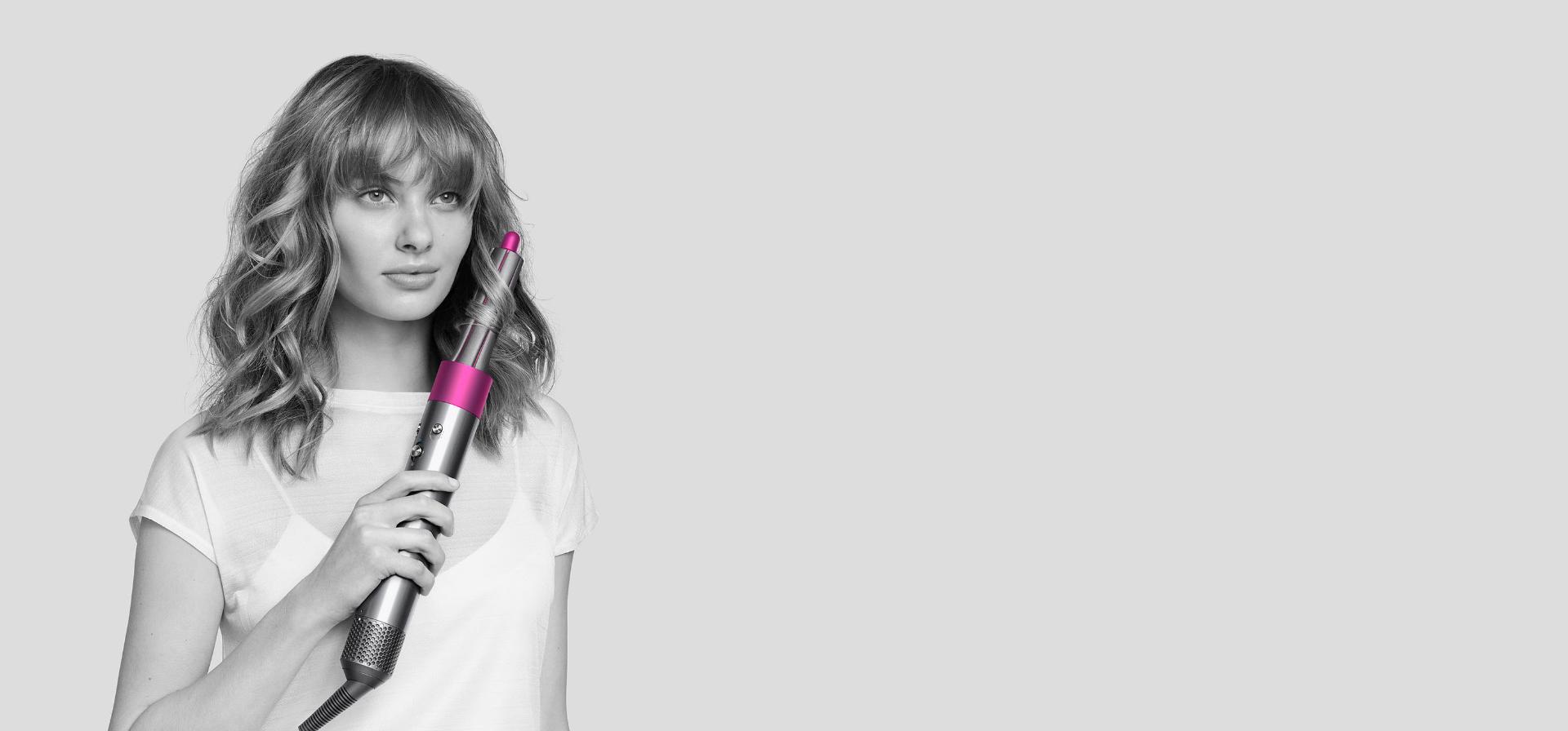 Woman curls her hair with Dyson Airwrap styler.