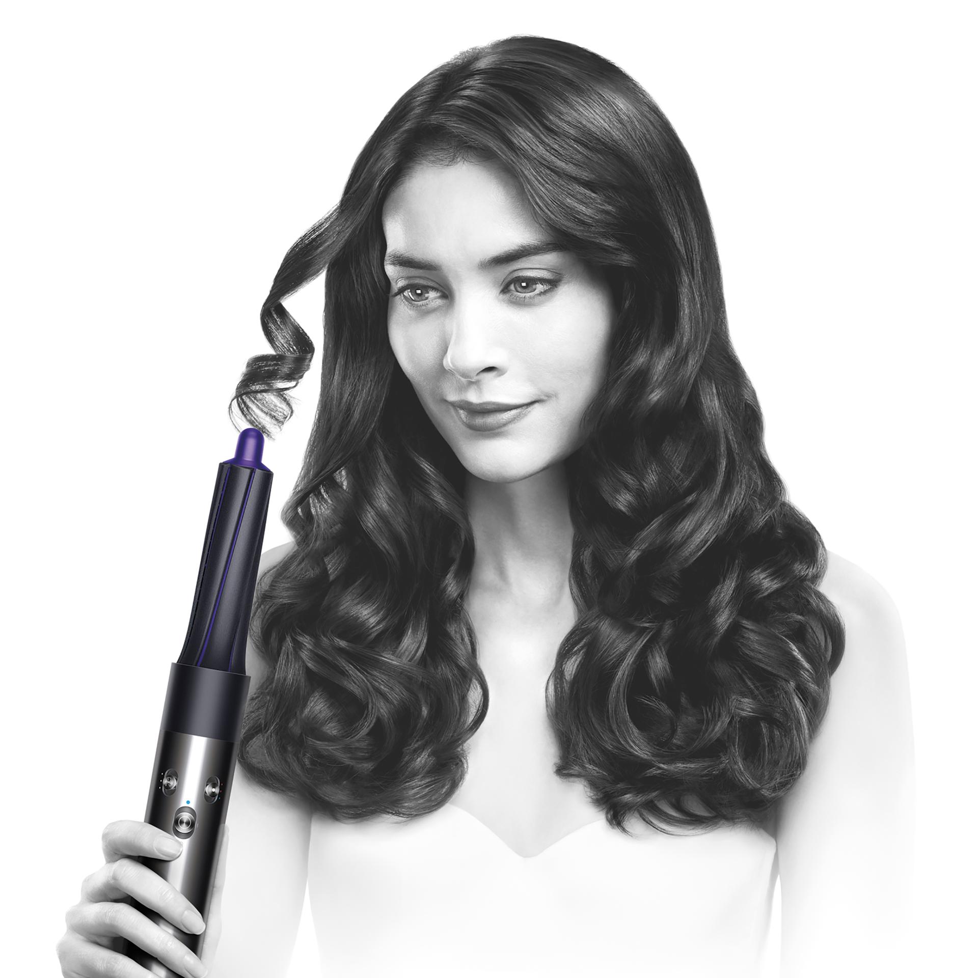 Photograph of a woman using the Airwrap™️ styler.