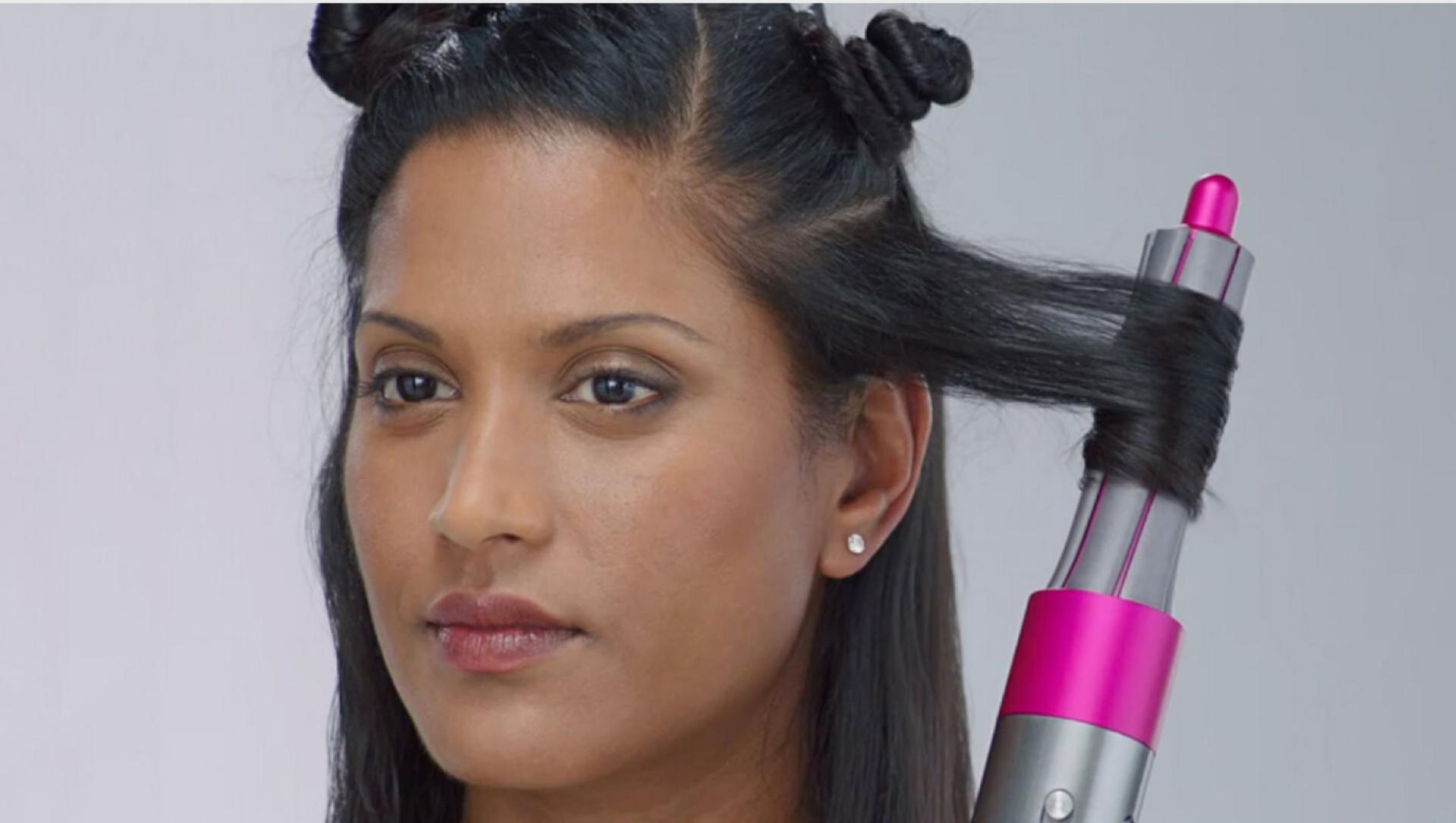 O femeie ținând orizontal bara de ondulare