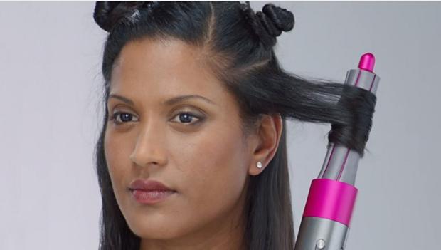 O femeie ținând orizontal bara de ondulare