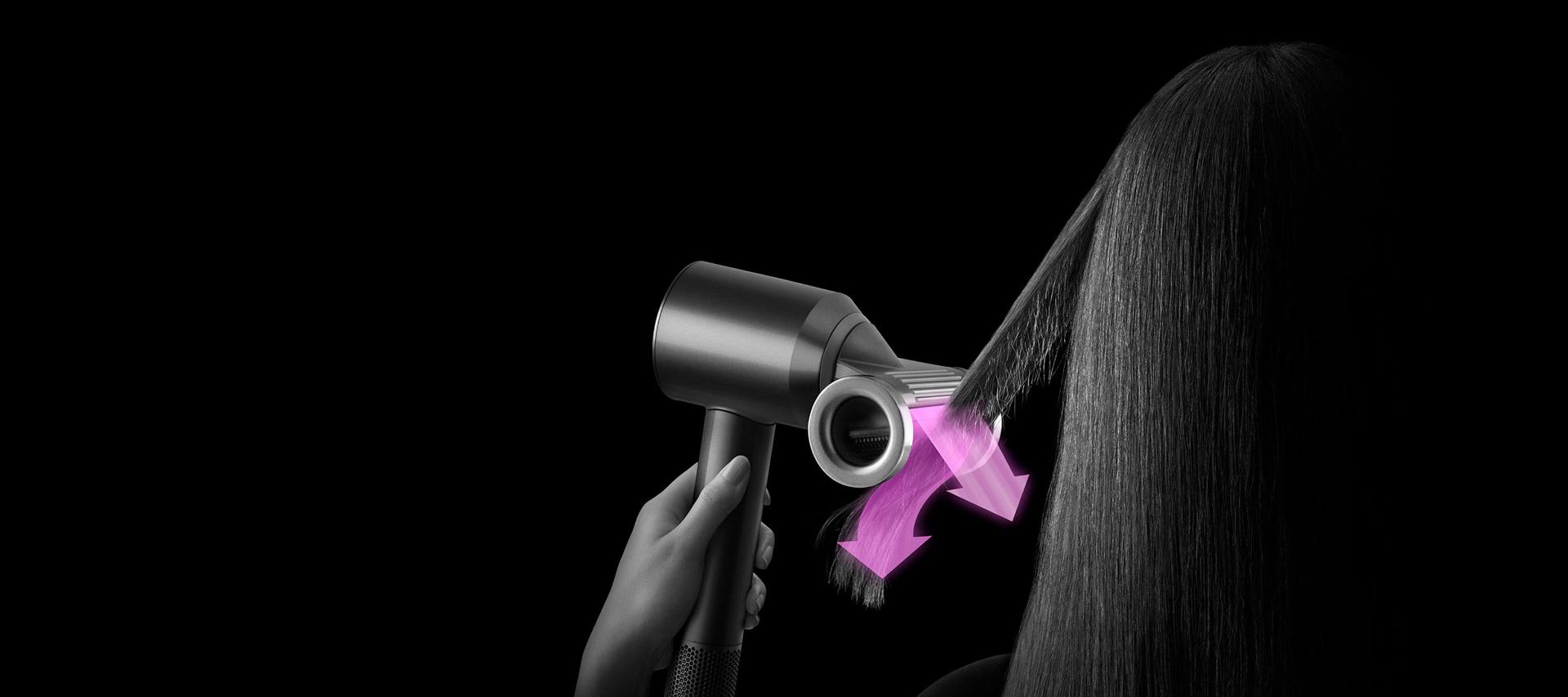 Model styling hair with Dyson Supersonic Flyaway attachment.