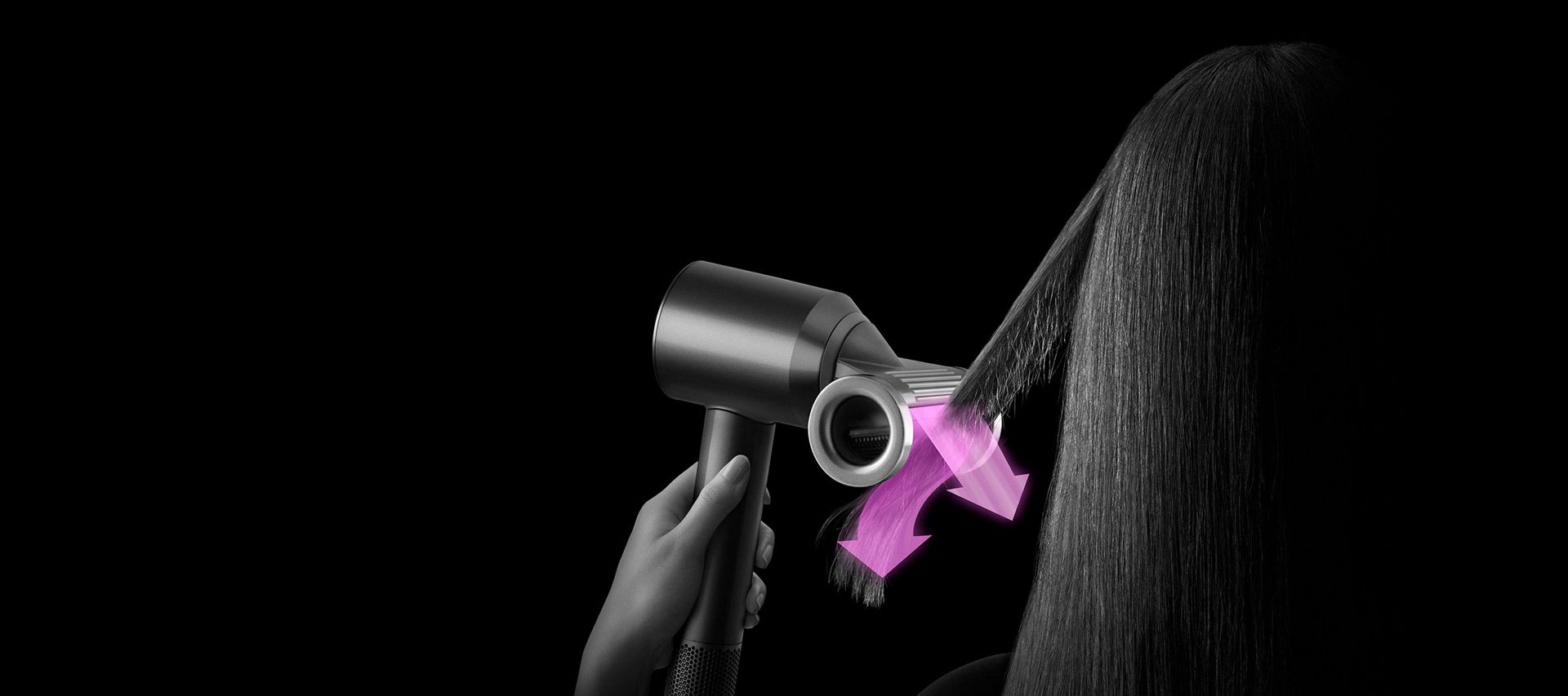 Model styling hair with Dyson Supersonic Flyaway attachment.