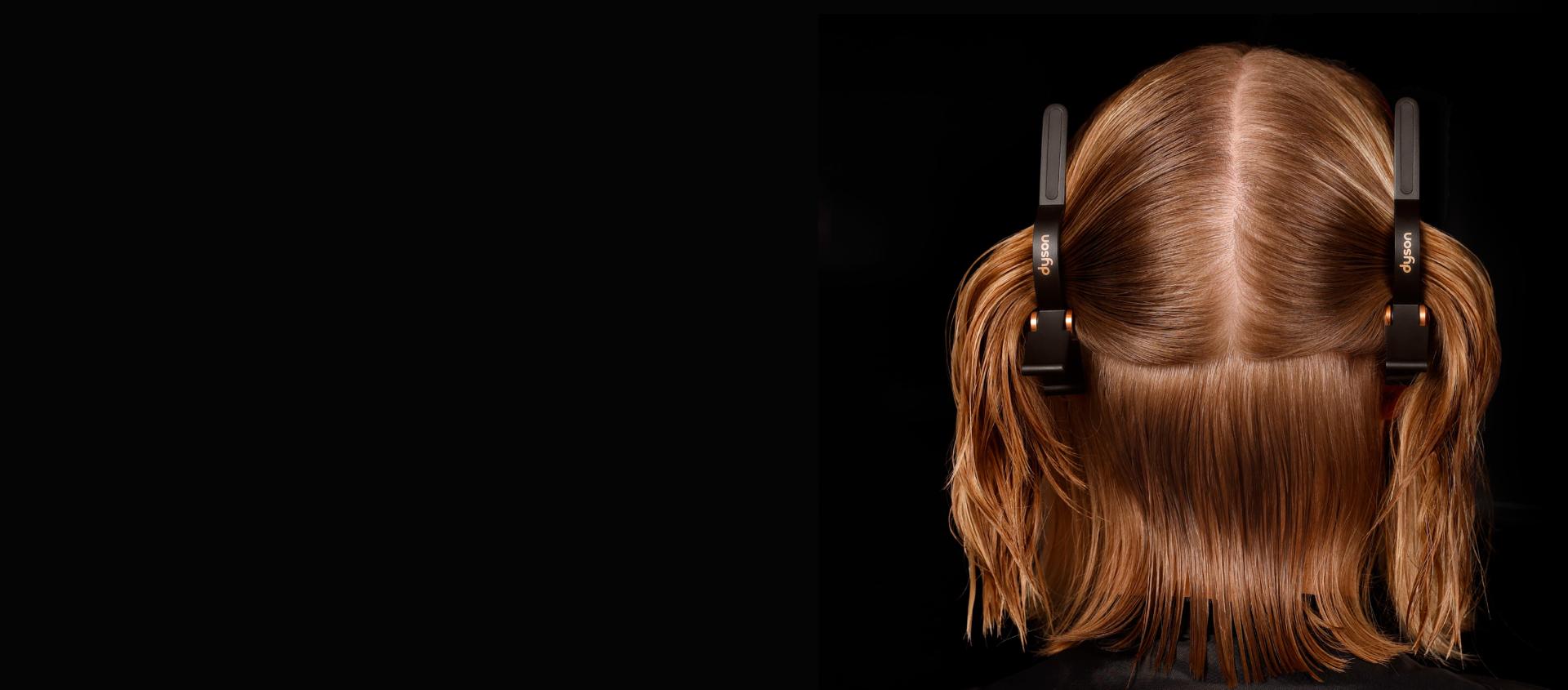 Modele ar divām profilējošām matu sprādēm sadala matus šķipsnās.