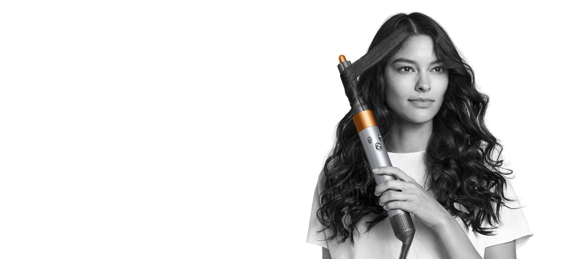 Mujer estiliza su cabello con el estilizador Dyson Airwrap color cobre