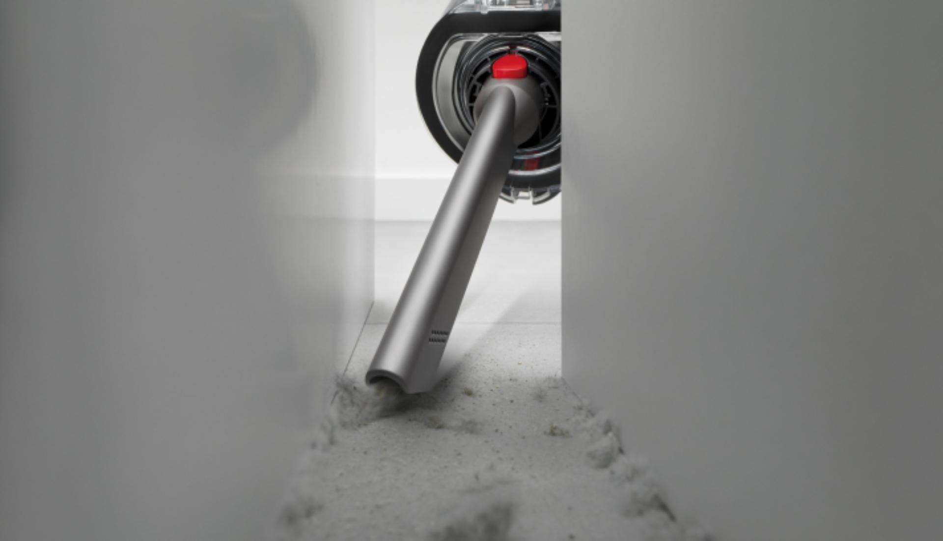 The Crevice tool is used to clean behind a cabinet.