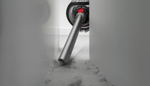 The Crevice tool is used to clean behind a cabinet.