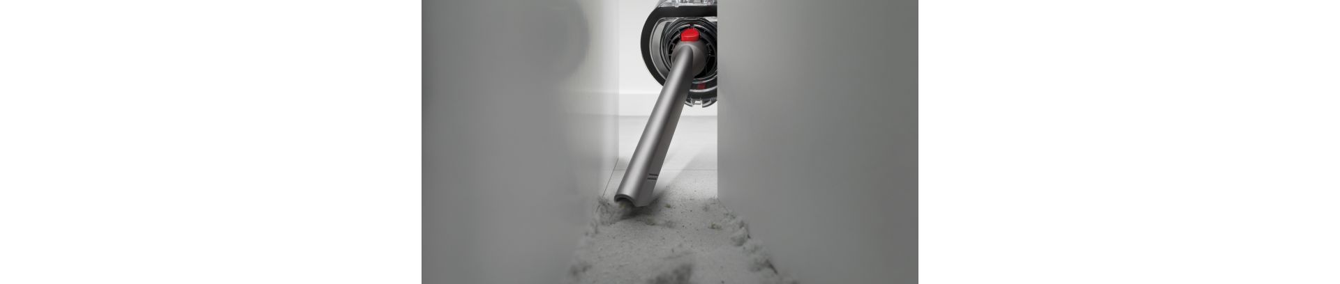 The Crevice tool is used to clean behind a cabinet.