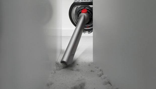 The Crevice tool is used to clean behind a cabinet.
