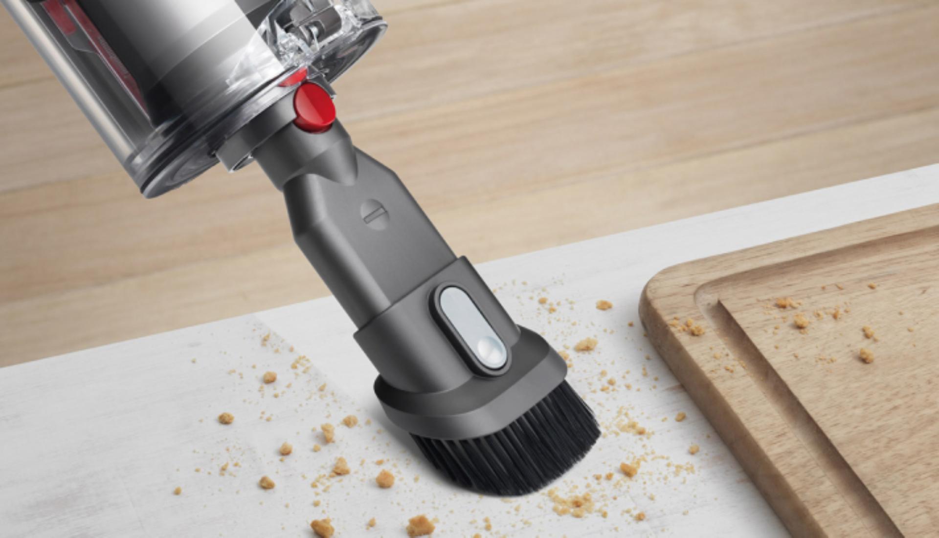 The Combination tool is used with its retractable brush to clean crumbs from a surface.